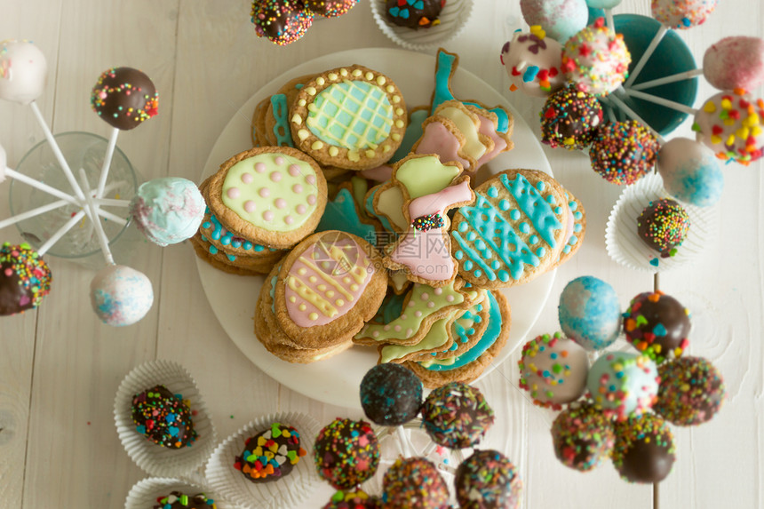 糖果蛋糕和饼干在甜圈的木制餐桌上各种糖果蛋糕和饼干的顶端视图图片