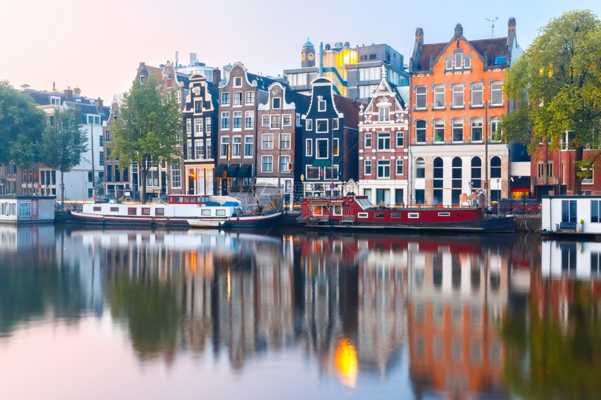 阿姆斯特丹运河荷兰日出时有典型的荷兰码头房屋和船只图片