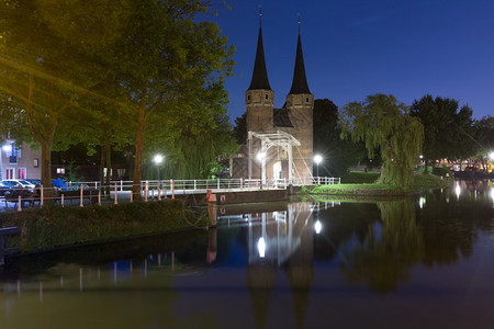 东门Oostpoort与白帆桥沿DelftseSchie运河晚上在荷兰Delft图片