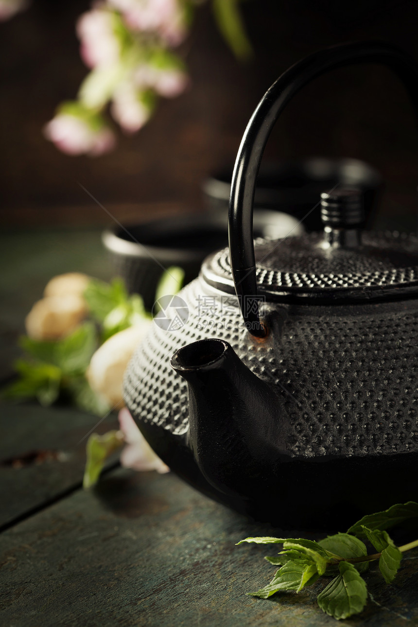 茶叶概念杯和传统壶配有盛开的春树枝图片