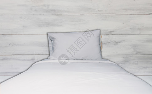 白色紧贴的床铺和枕头有白色木壁纹身背景图片