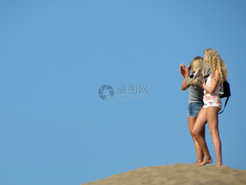 一对在沙丘上拍照的游客图片