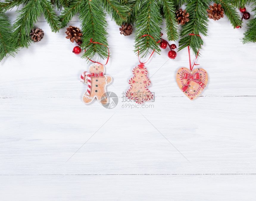 白色木质背景与饼干挂在壁架树枝上圣诞节的概念图片