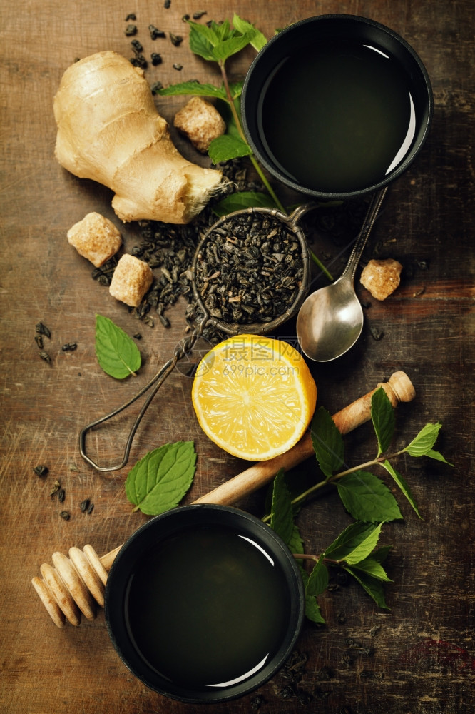 一杯茶柠檬姜汁和木背景的薄荷图片