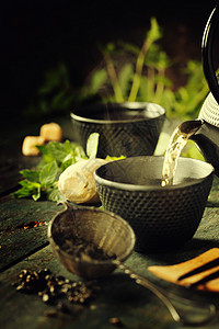 日本茶壶和木底有薄荷茶的日本壶和杯倒入图片
