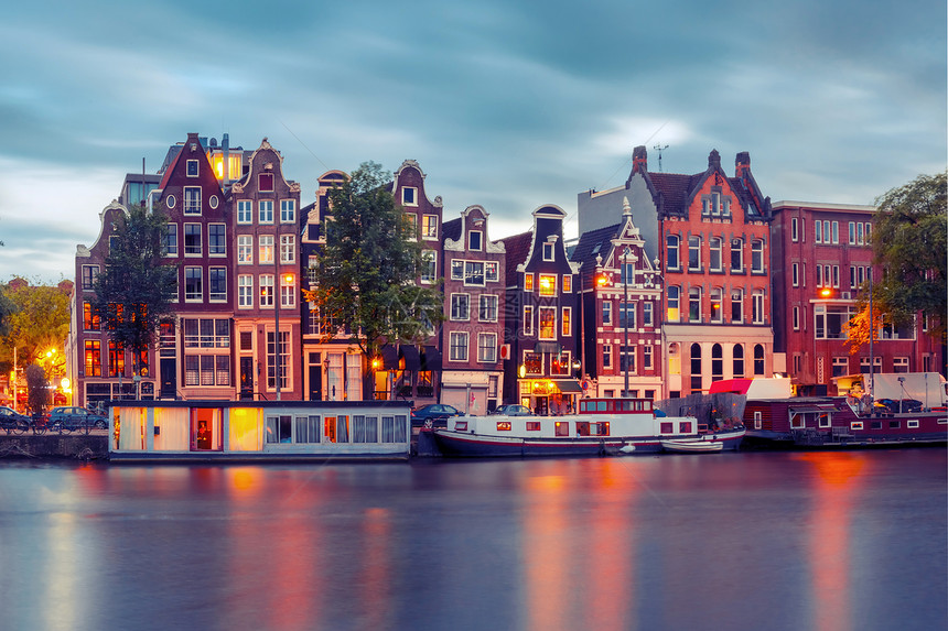 荷兰阿姆斯特丹运河典型的荷兰码头房屋和船只在清晨蓝色时段停泊图片