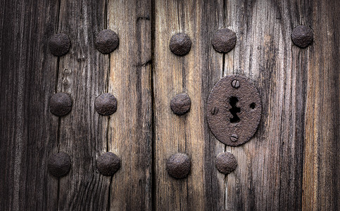 旧木制门的钥匙孔生锈和风化这个图像已被处理成一个更有影响戏剧镜头图片