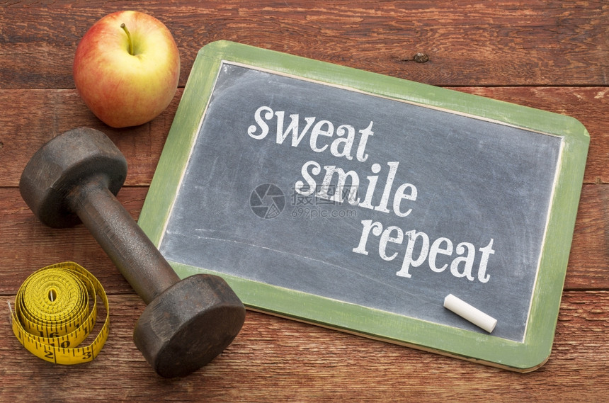 汗水微笑重复健身概念黑板牌用哑铃苹果和磁带测量器对抗经风化的红漆谷仓木图片