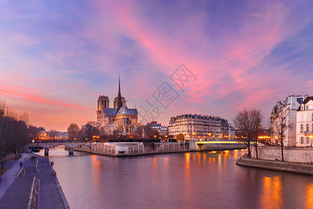 法国巴黎圣母教堂塞纳河和法国巴黎圣母教堂上空的光辉日落图片