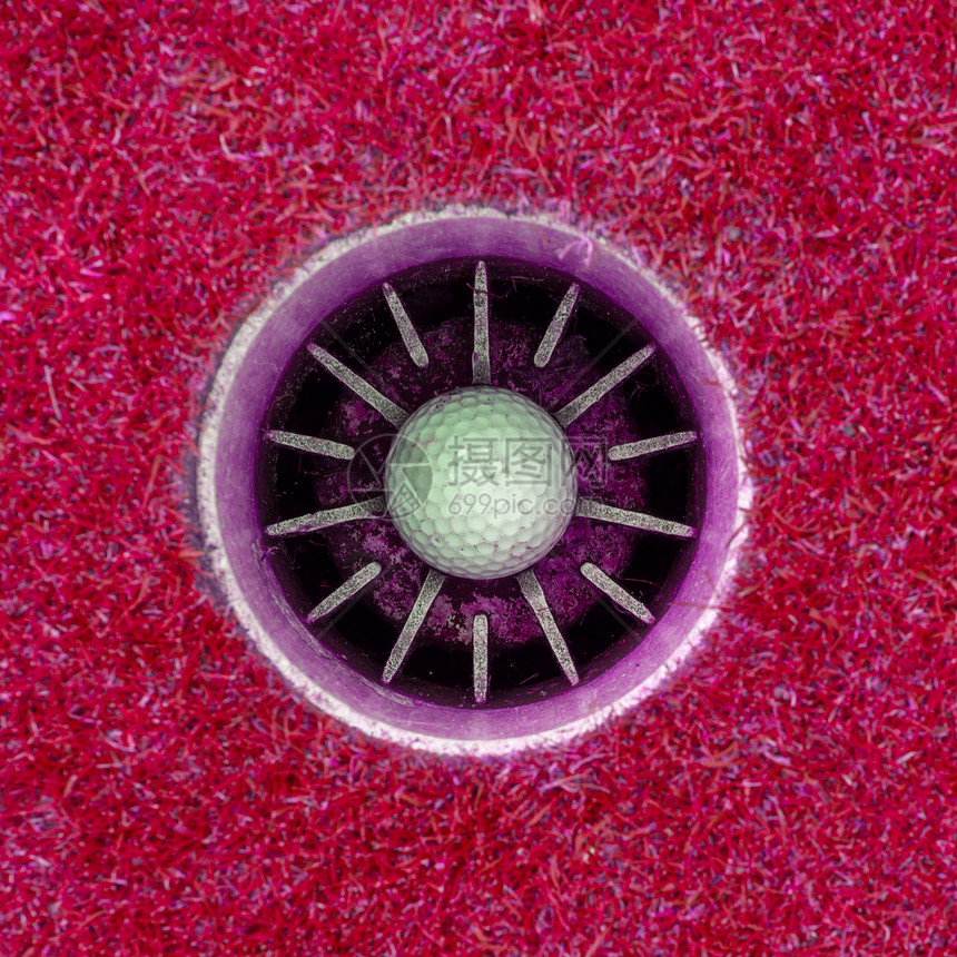 一洞高尔夫球在杯子里粉红色图片