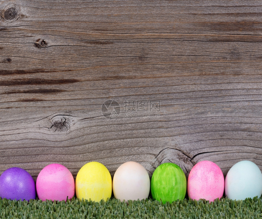 青草上多彩的复活节鸡蛋装饰里面有生锈的木头图片