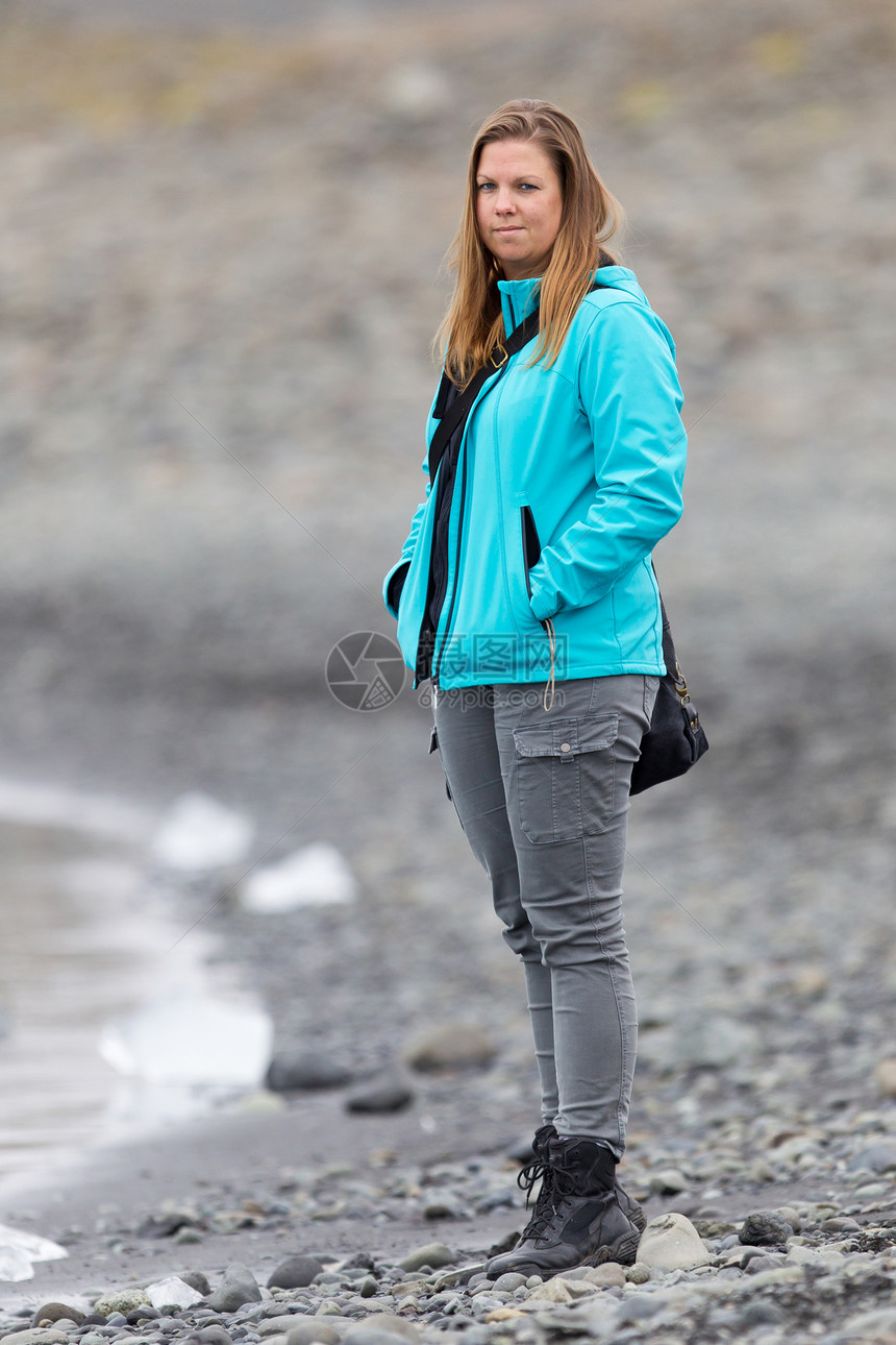 冰岛南部Jokulsarlon冰川环礁湖海滩上行走的妇女图片