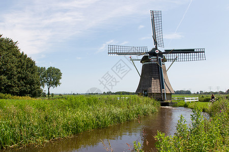 在夏季风景中传统古老的荷兰风车背景图片