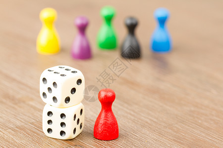 六只彩色棋子和两骰在木背景上被孤立背景