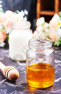 鲜花背景的牛奶和蜂蜜背景图片