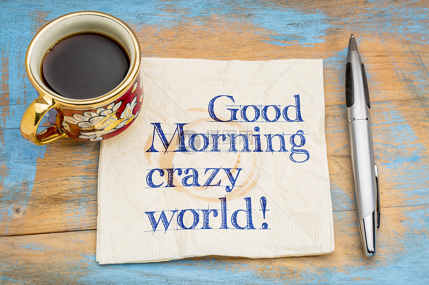 早上好疯狂的世界在餐巾纸上的笔迹加一杯咖啡图片