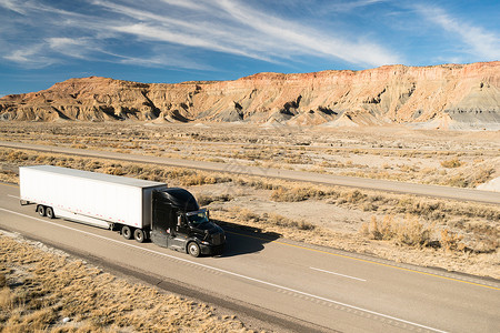 一辆黑色集装箱卡车横跨犹他州的高速公路上图片