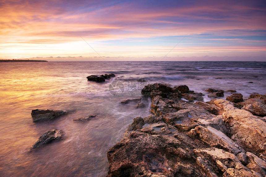 美丽的海景日落时与岩石自然构成图片