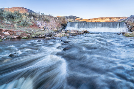 北科罗拉多州山丘的一个小水坝ParkCreek正在从Poudre河北福克改道供水以填充下游的水库背景图片
