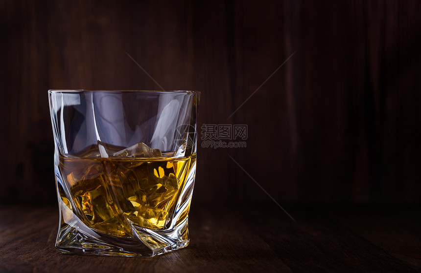 一杯苏格兰威士忌和冰杯放在木制背景上带有复制空间图片