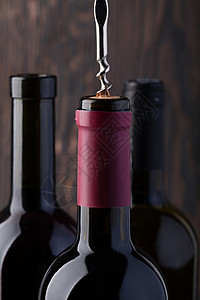 旋塞瓶红酒和装红和在旧木制桌上的瓶装酒背景