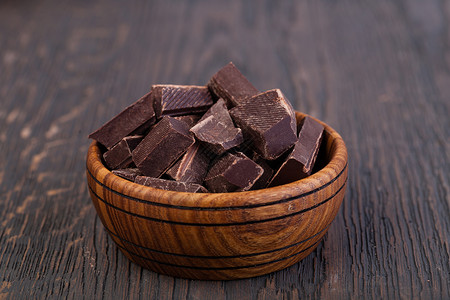 木制桌上的天然黑巧克力块图片
