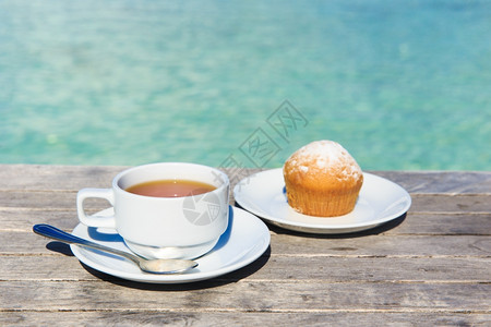 茶杯在桌边背景是海与图片