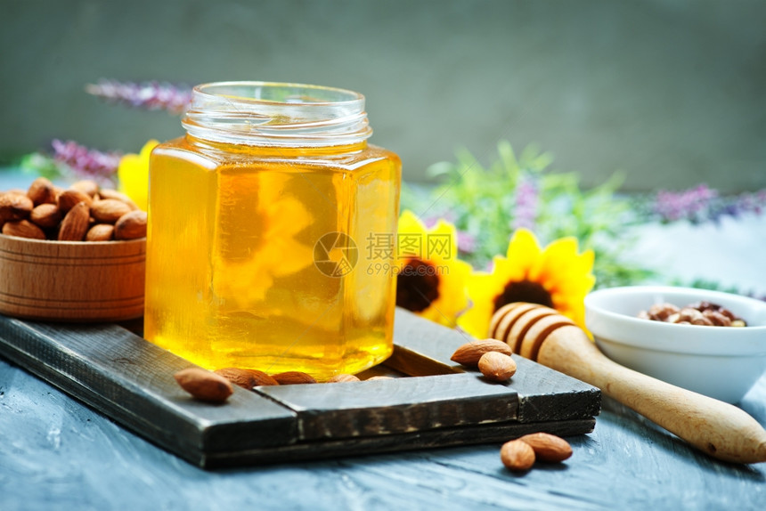 蜂蜜在玻璃罐中一张桌子上图片