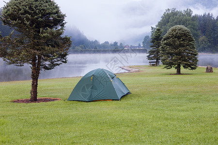 在湖附近绿草坪上扎营帐篷图片