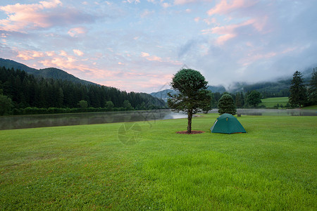 在湖附近绿草坪上扎营帐篷背景图片