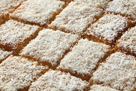 摩洛哥新鲜烤奶油酸蛋糕切成一块被装饰的白椰子全框背景图片
