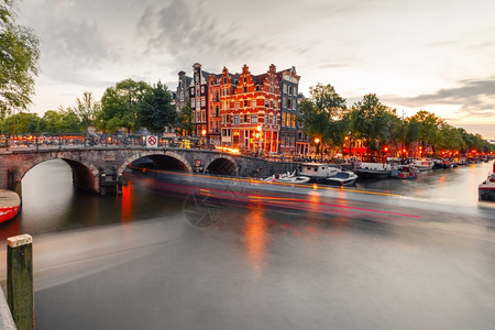 欧普照明阿姆斯特丹运河和桥梁的夜间城市景色阿姆斯特丹运河桥梁和典型的房屋船只和自行车晚上清晨蓝色时荷兰背景