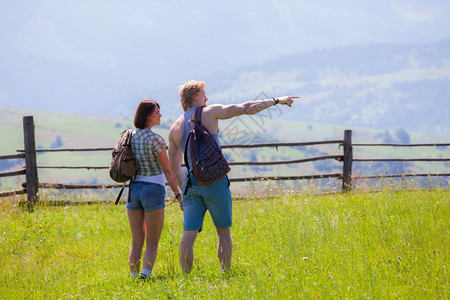 一对夫妇在夏季草原一起走来去环顾乡村风景图片
