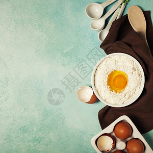 用面粉鸡蛋和厨房工具烤背景放在蓝绿色的桌子上顶级风景平面格图片