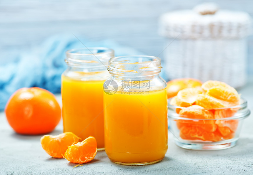在玻璃库和桌上的橘子汁图片