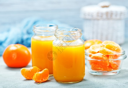 在玻璃库和桌上的橘子汁高清图片