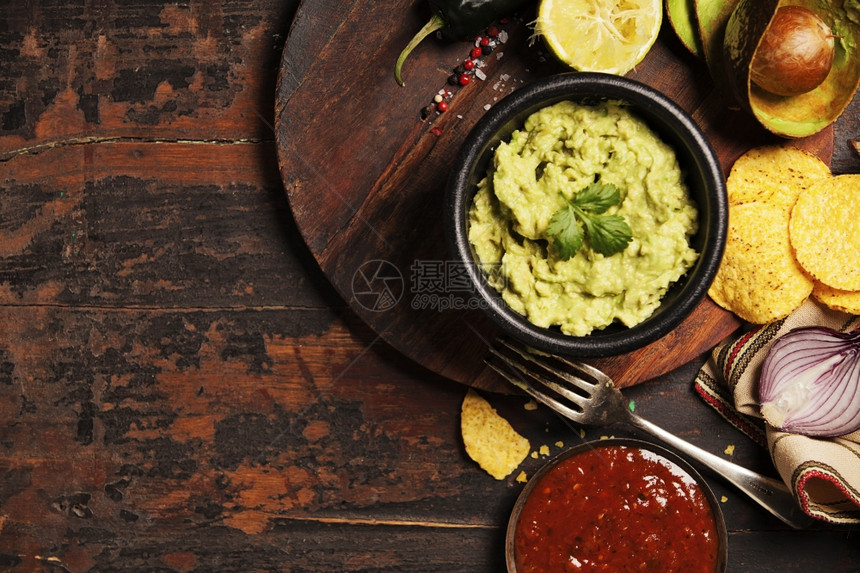 墨西哥玉米薯片配有自制新鲜的瓜卡莫菜酱和古老背景的萨尔图片