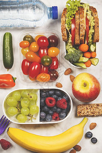 健康午餐盒配有三明治和新鲜蔬菜水果图片