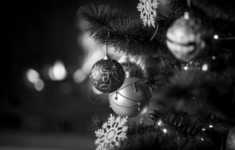 黑色和白的一针美丽装饰圣诞树在房子燃烧的壁炉前放在上图片