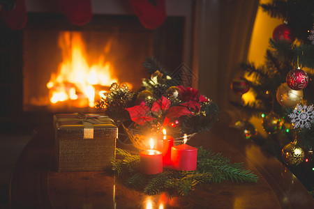 圣诞花圈在客厅用红蜡烛和燃烧的壁炉图片