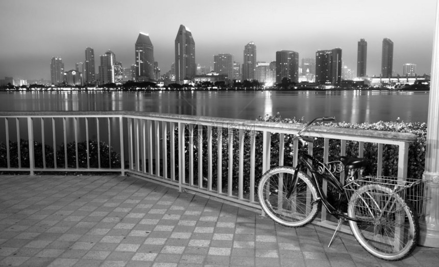 一辆自行车被锁在科罗纳多的栅栏上晚和圣地亚哥在背景里图片