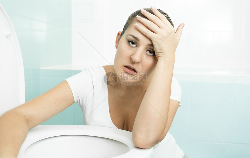 年轻孕妇生病和靠着厕所的肖像图片