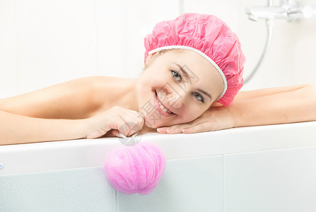 穿着粉红色浴帽在洗澡时化妆的粉红色浴帽年轻女子肖像图片