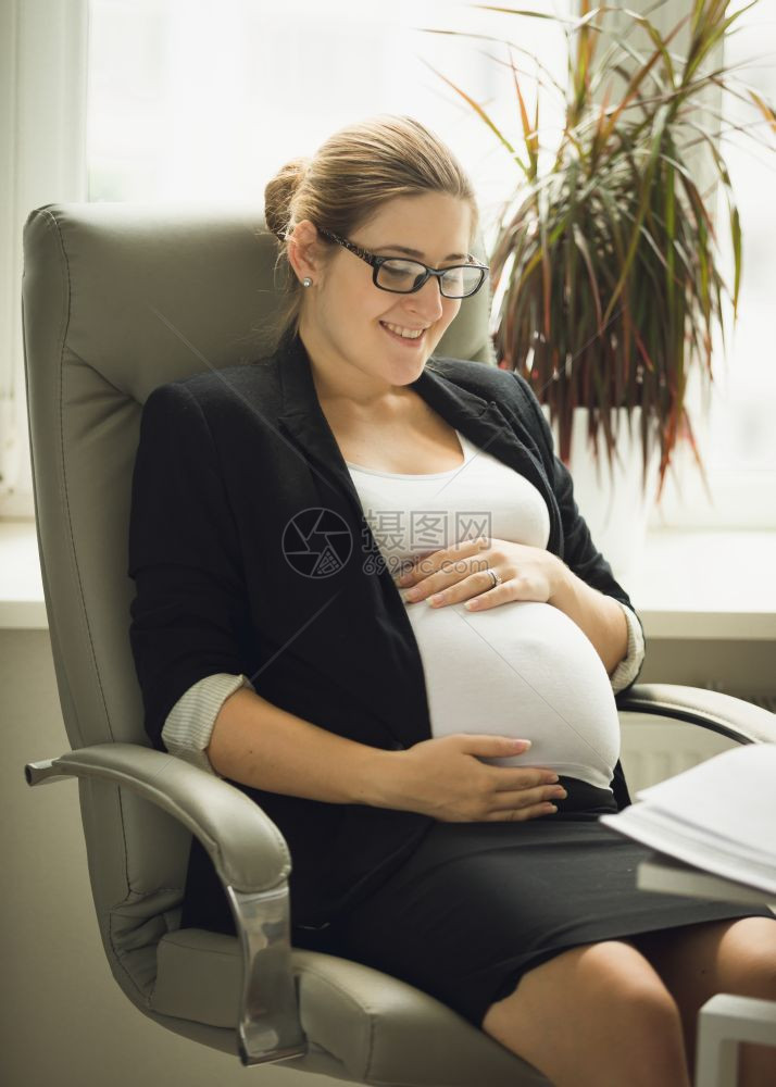 怀孕的女商人摸着肚子图片