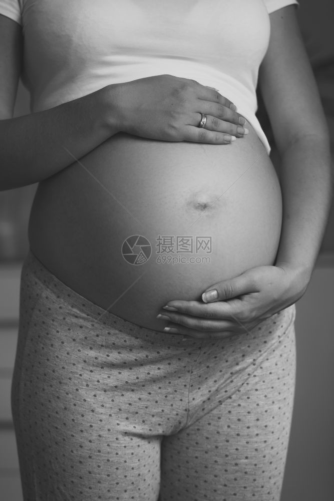孕妇在大肚子上握手的照片图片
