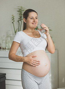 清晨带着杯水冒的快乐孕妇肖像图片