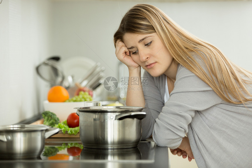 心烦意乱的女人在厨房煮汤的肖像图片