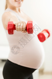 孕妇装哑铃的近身照片背景图片
