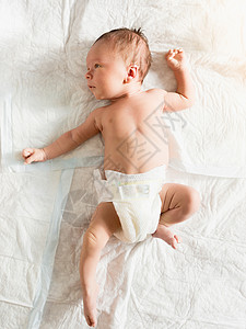 快乐笑的婴儿肖像躺在床上与响声图片