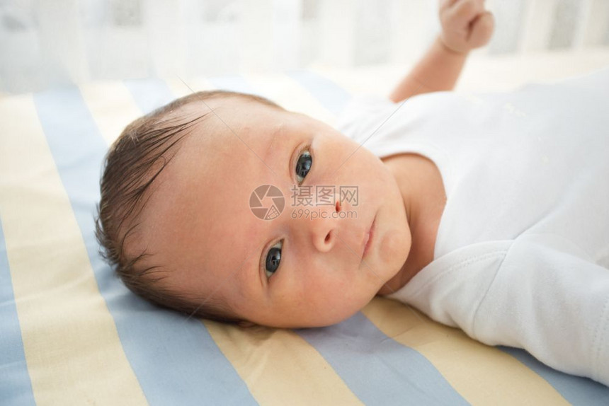 躺在床上的可爱新生婴儿近视肖像图片